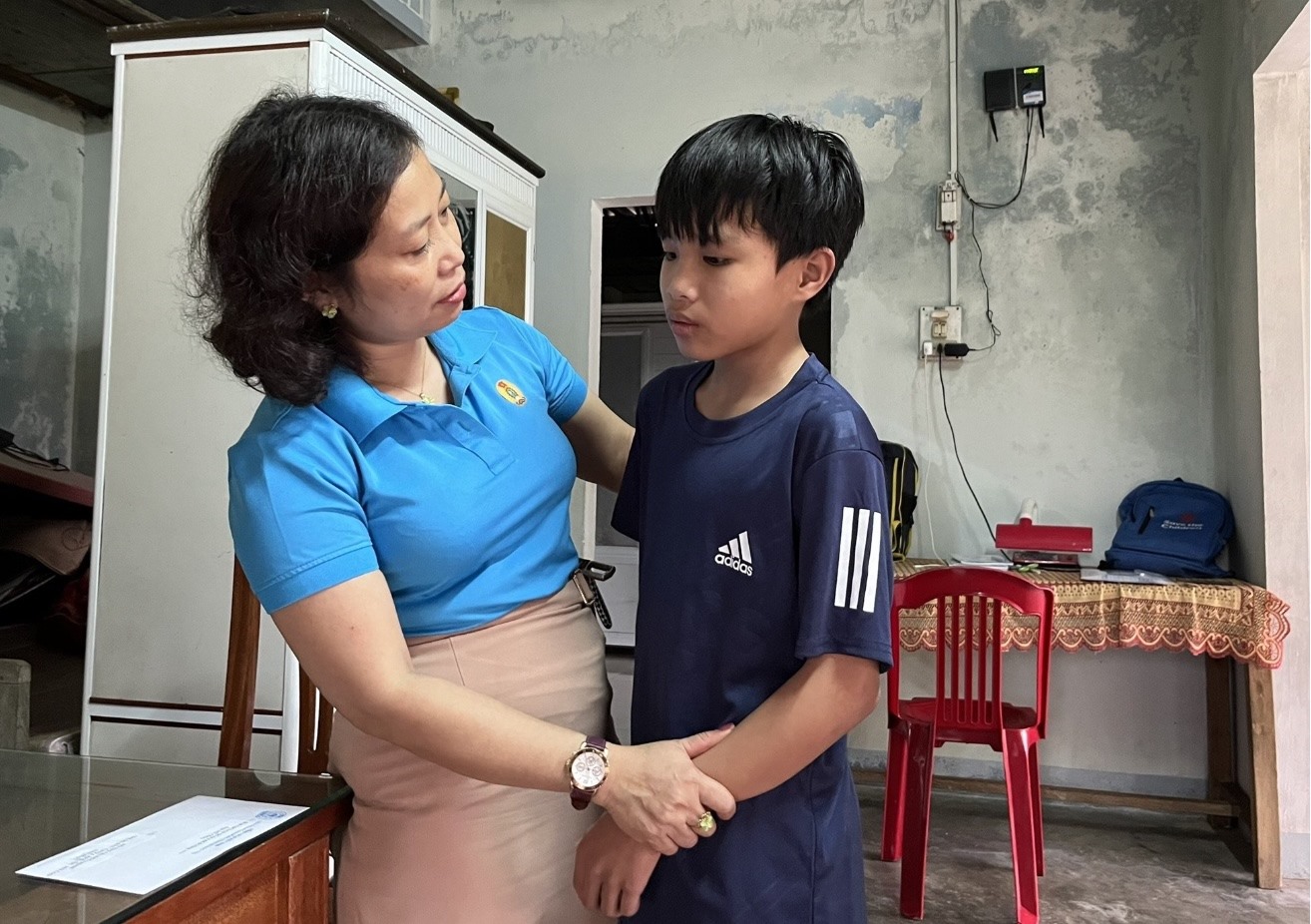 Cán bộ Công đoàn Cơ quan Liên đoàn Lao động tỉnh Quảng Trị động viên, nhận đỡ đầu con trai của chị Lê Thị Điệp. Ảnh: Trần Diễm