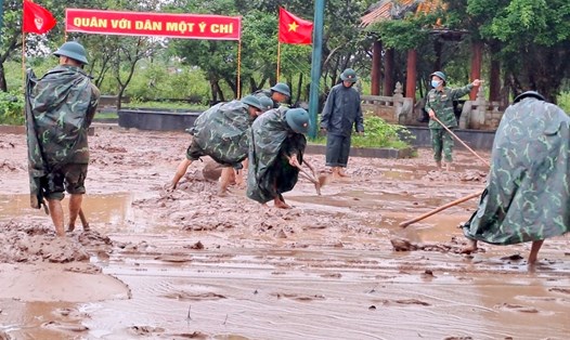 Trung đoàn Bộ binh 842 cào lớp bùn non sau khi nước lũ rút. Ảnh: TT.