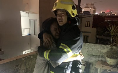 Hình ảnh xúc động giữa lính cứu hoả với người dân sau khi được giải cứu khỏi đám cháy. Ảnh: H.Dũng