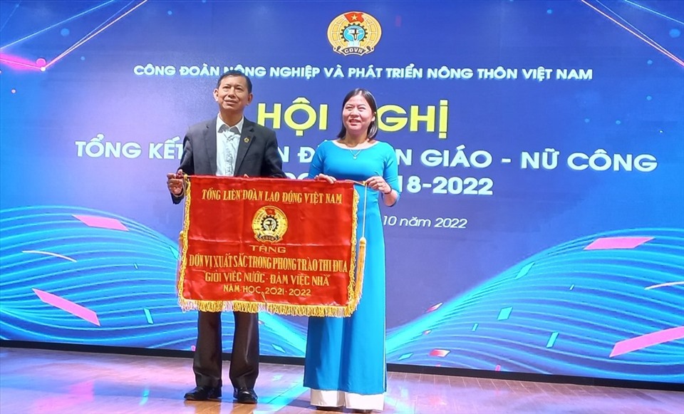 Ông Vũ Mạnh Tiêm - Phó Trưởng ban Tuyên giáo Tổng Liên đoàn Lao động Việt Nam trao tặng Cờ thi đua cho Công đoàn Trường Đại học Nông Lâm Bắc Giang đã có thành tích xuất sắc trong phong trào thi đua “Giỏi việc nước, Đảm việc nhà” năm học 2021 – 2022. Ảnh: Quang Hùng