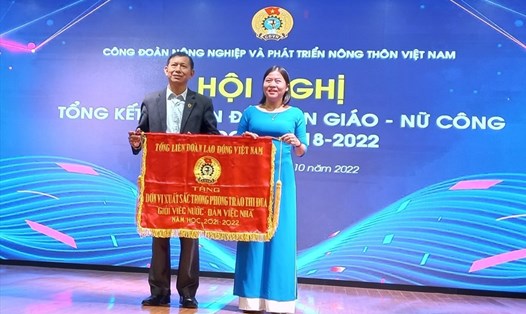 Ông Vũ Mạnh Tiêm - Phó Trưởng ban Tuyên giáo Tổng Liên đoàn Lao động Việt Nam trao tặng Cờ thi đua cho Công đoàn Trường Đại học Nông Lâm Bắc Giang đã có thành tích xuất sắc trong phong trào thi đua “Giỏi việc nước, Đảm việc nhà” năm học 2021 – 2022. Ảnh: Quang Hùng