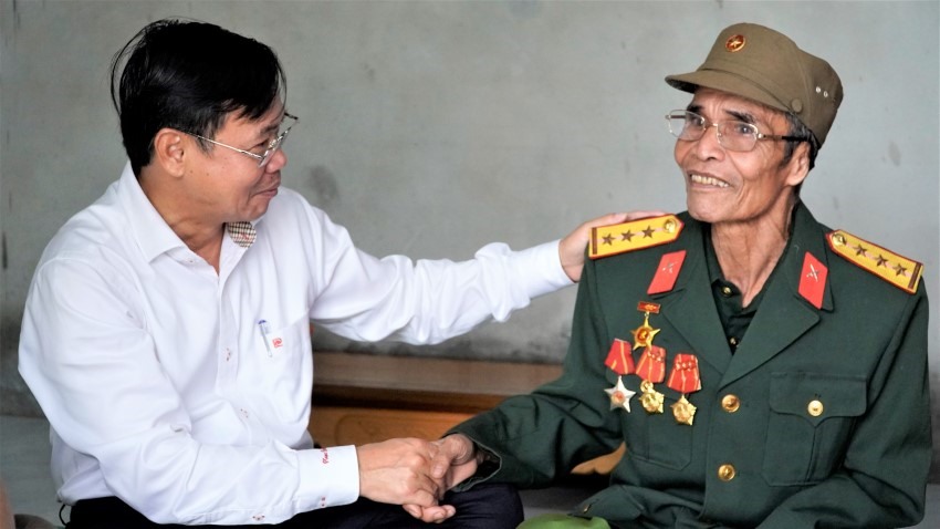 Giám đốc Công ty Điện lực Quảng Trị Phan Văn Vĩnh ân cần hỏi thăm sức khỏe vợ chồng cựu chiến binh Hồ Văn Đeo. Ảnh: Minh Thành