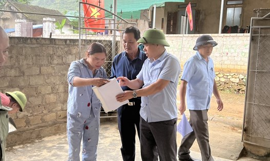 Phó Chủ tịch UBND huyện Quỳ Hợp Trần Đức Lợi và đoàn công tác trao đổi với người dân về kế hoạch sửa chữa nhà bị hư hỏng do sụt lún đất. Ảnh: QĐ