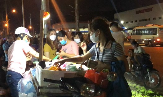 Công nhân khu công nghiệp Quang Châu (tỉnh Bắc Giang) mua đồ ăn trước khi vào làm ca đêm. Ảnh: Bảo Hân