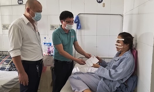 Đại diện Quỹ Xã hội từ thiện Tấm lòng Vàng thăm hỏi, trao quà hỗ trợ cho nữ công nhân Nguyễn Thị Vĩnh đang điều trị tại Bệnh viện Hữu nghị đa khoa Nghệ An. Ảnh: Lê Na