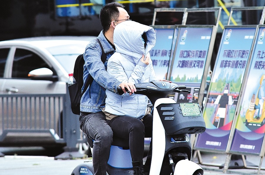 Người dân cảm nhận không khí lạnh khi nhiệt độ giảm xuống 3 độ C ở Thẩm Dương, tỉnh Liêu Ninh, Trung Quốc hôm 3.10. Ảnh: China Daily