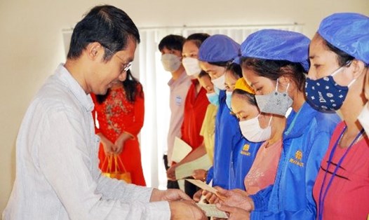 Ông Kevin - Phó Tổng Giám đốc công ty TNHH May mặc Makalot Việt Nam (Hải Dương) - trao sổ tiết kiệm cho công nhân khó khăn. Ảnh: DT