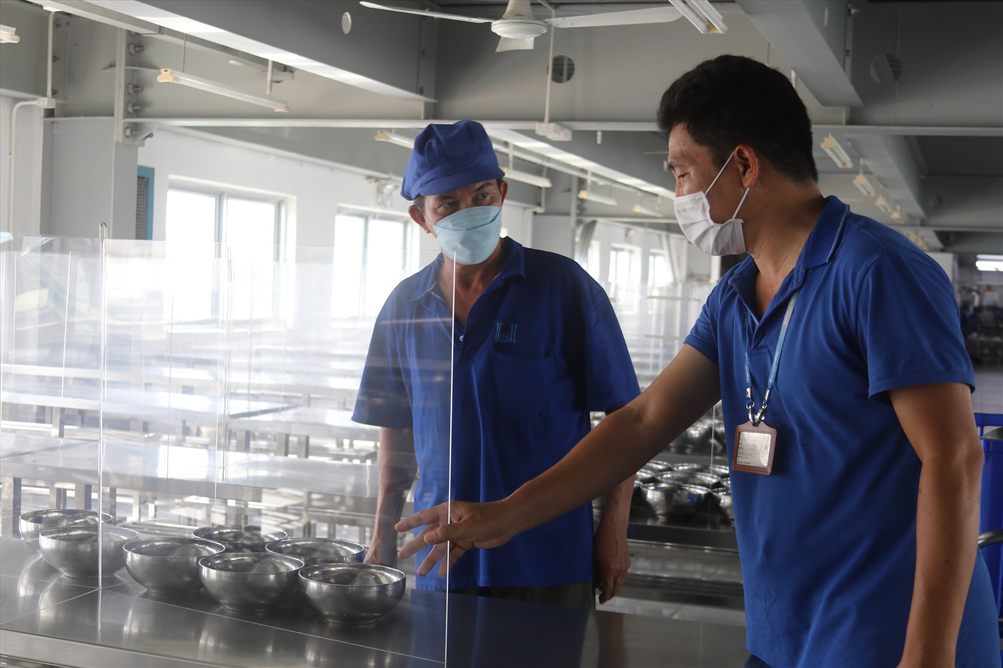 Chủ tịch CĐCS Công ty TNHH May mặc đồ bơi Thống Nhất (KCN Suối Dầu) ông Vương Phương Anh (phải) kiểm tra trước bứa ăn ca của công nhân. Ảnh: P.Linh