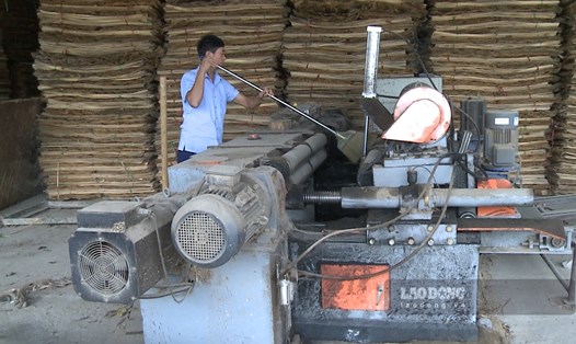 Ông Nguyễn Quốc Hà - Chủ xưởng gỗ tại khu 2, xã Ấm Hạ đi quét lớp bụi dày phủ trên máy móc của mình sau lâu ngày dừng hoạt động.