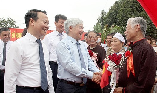 Ông Đỗ Văn Chiến (giữa) và lãnh đạo tỉnh Yên Bái chia sẻ niềm vui với người dân xã Quy Mông khi xã đạt chuẩn NTM nâng cao. Ảnh: Đức Toàn.