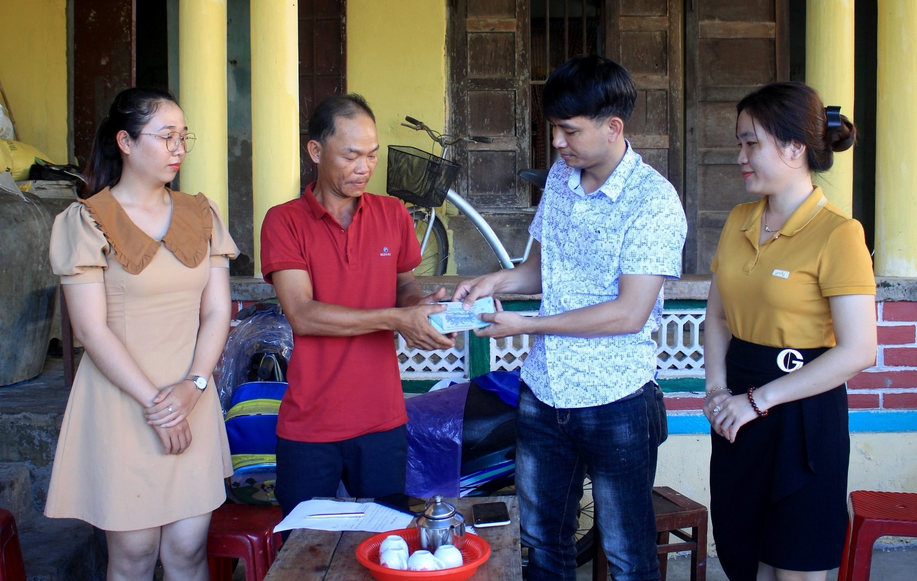 Đại diện Quỹ XHTT Tấm lòng Vàng - Báo Lao Động trao quà hỗ trợ của bạn đọc cho gia đình anh Lê Thùy. Ảnh: Ngọc Viên