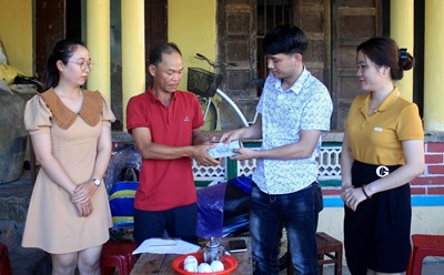 Đại diện Quỹ XHTT Tấm lòng Vàng - Báo Lao Động trao quà hỗ trợ của bạn đọc cho gia đình anh Lê Thùy. Ảnh: Ngọc Viên