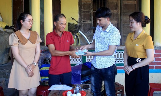 Đại diện Quỹ XHTT Tấm lòng Vàng - Báo Lao Động trao quà hỗ trợ của bạn đọc cho gia đình anh Lê Thùy. Ảnh: Ngọc Viên