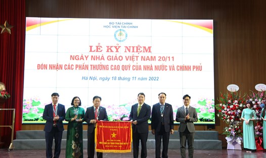 Thứ trưởng Bộ Tài chính Cao Anh Tuấn (đứng thứ 3 từ phải sang) trao tặng Cờ thi đua của Chính phủ cho tập thể Học viện Tài chính. Ảnh: Tường Vân