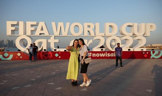 Du khách chụp ảnh với tấm biển FIFA World Cup ở Doha vào ngày 16.11.2022, trước thềm Vòng chung kết World Cup 2022 tại Qatar. Ảnh: Adrian Dennis/AFP