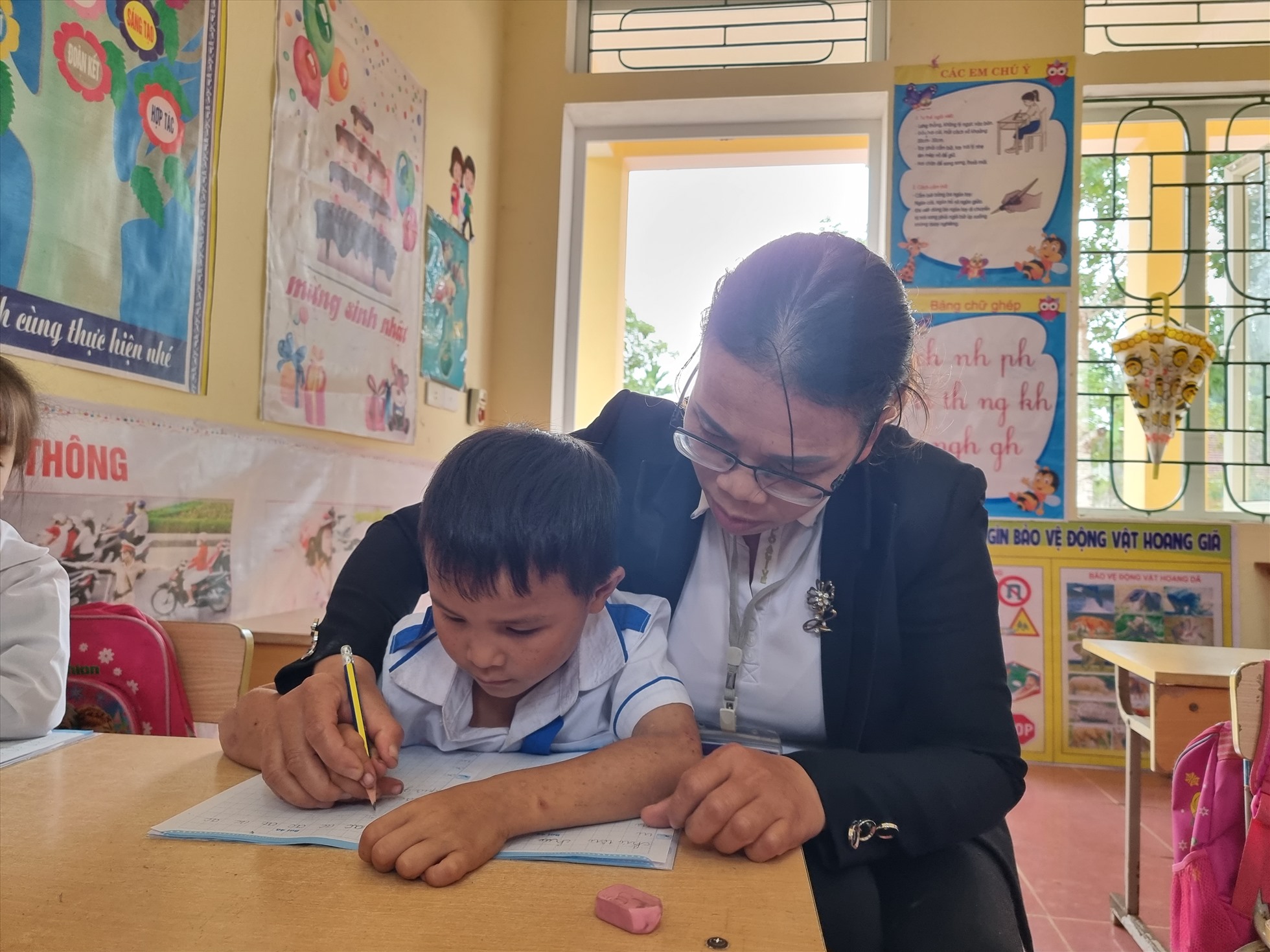 Cô Lương Thị Thắm - Trường Tiểu học Tiền Phong 4 - Quế Phong - Nghệ An luyện viết cho học sinh tại điểm trường Huồi Muồng. Ảnh: Quang Đại