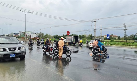 Lục lượng chức năng chặn Quốc lộ 1A đoạn qua tỉnh Quảng Nam vì nước lũ dâng cao. Ảnh: Đức Tài