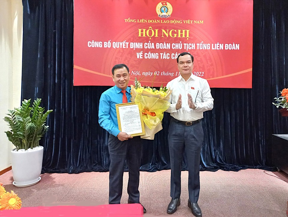 Ông Nguyễn Đình Khang - Uỷ viên Trung ương Đảng, Chủ tịch Tổng LĐLĐVN trao Quyết định và tặng hoa cho ông Nguyễn Văn Bắc (bên trái). Ảnh: Hùng Quang