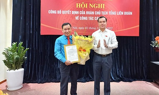Ông Nguyễn Đình Khang - Uỷ viên Trung ương Đảng, Chủ tịch Tổng LĐLĐVN trao Quyết định và tặng hoa cho ông Nguyễn Văn Bắc (bên trái). Ảnh: Hùng Quang