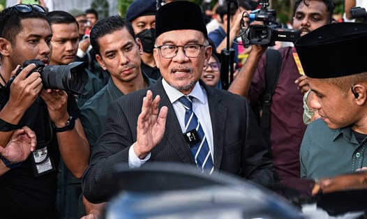 Ông Anwar Ibrahim (giữa) vẫy tay chào khi rời đi sau cuộc gặp Quốc vương Malaysia ngày 22.11.2022. Ảnh: AFP