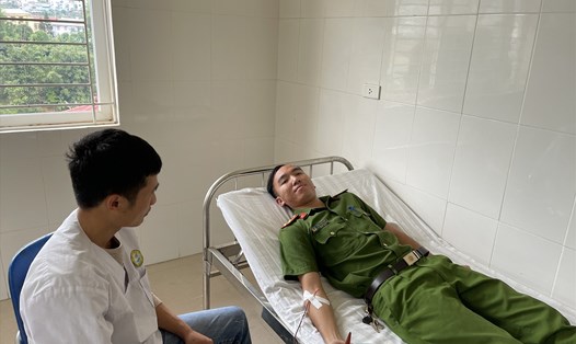 Thượng úy Trần Văn Huần - Phó trưởng Công an xã Phiêng Ban, huyện Bắc Yên (Sơn La) tiến hành lấy máu hỗ trợ bệnh nhân Pàng. Ảnh: Hiếu Thiên
