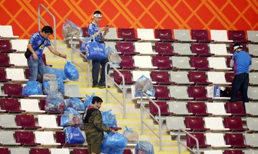 Cổ động viên Nhật Bản nán lại dọn rác sau khi đội nhà giành chiến thắng 2-1 trước tuyển Đức.  Ảnh: AFP