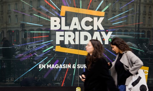 Người mua sắm đi qua khu vực có dòng chữ Black Friday. Ảnh: AFP