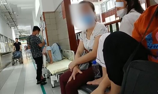 Trong phòng chật chội, nhiều bệnh nhân phải nằm, ngồi ngoài hành lang ở Bệnh viện Bạch Mai. Ảnh: Ánh Trang