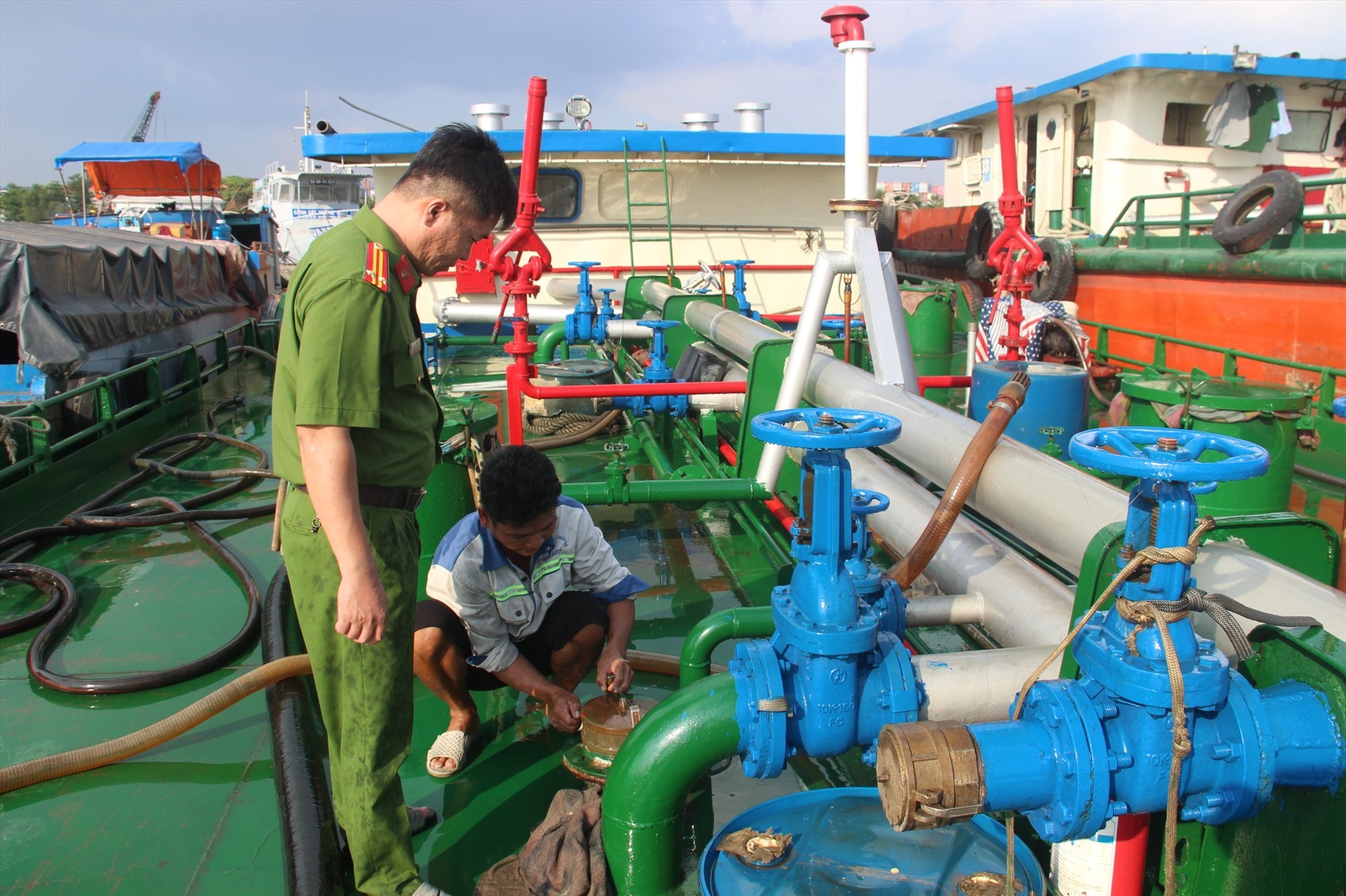 Lực lượng công an phát hiện bắt quả tang các đối tượng hút xăng trộm từ tàu vận tải để bán. Ảnh: Hà Anh Chiến
