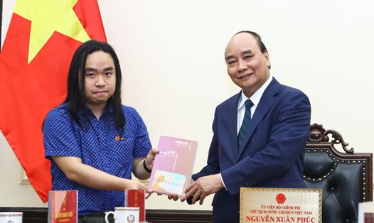 Nhà văn trẻ Nguyễn Bình tặng Chủ tịch nước Nguyễn Xuân Phúc tác phẩm Truyện Kiều song ngữ. Ảnh: VPCTN