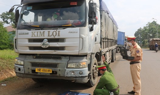 Lực lượng chức năng tỉnh Đắk Nông cân tải trọng xe chở cát trên quốc lộ 28. Ảnh: T.B.