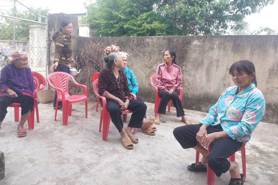Bà Lô (ngoài cùng bên phải) đang kể lại quảng thời gian lưu lạc bị bán sang Trung Quốc cho bà con hàng xóm ở xã Thịnh Lộc nghe. Ảnh: Trần Tuấn