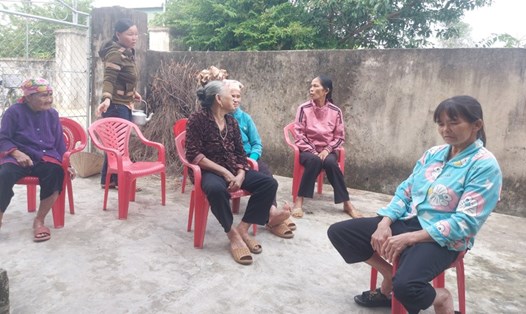 Bà Lô (ngoài cùng bên phải) đang kể lại quảng thời gian lưu lạc bị bán sang Trung Quốc cho bà con hàng xóm ở xã Thịnh Lộc nghe. Ảnh: Trần Tuấn