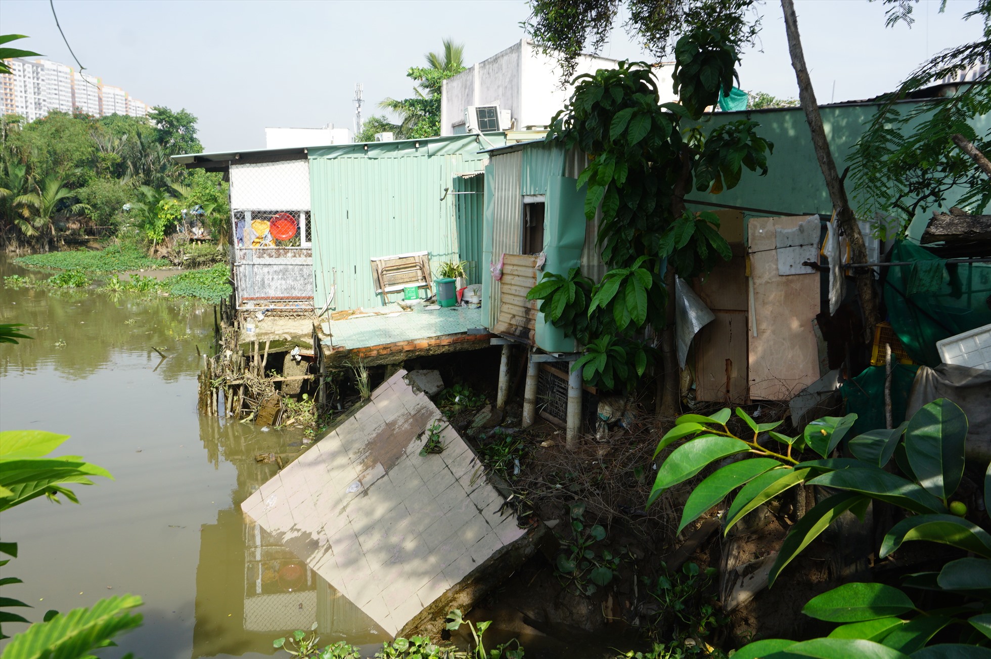Một phần căn nhà sát cầu Giồng Ông Tố (Thành phố Thủ Đức) bị sụt xuống rạch. Ảnh: Minh Quân