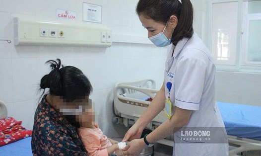 Bác sĩ khoa Các bệnh nhiệt đới, Bệnh viện Sản Nhi Quảng Ninh, khám cho trẻ mắc cúm B. Ảnh: ĐH