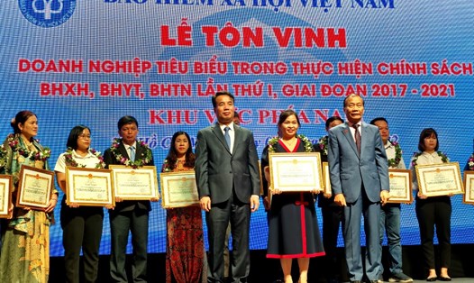 Đại diện BHXH Việt Nam và Liên đoàn Thương mại và công nghiệp Việt Nam tặng Bằng khen cho các doanh nghiệp tiêu biểu trong thực hiện chính sách 
BHXH, BHYT, BHTN. Ảnh: Nam Dương