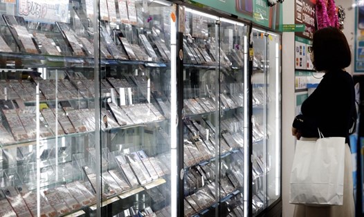 Một khách hàng xem trưng bày điện thoại di động cũ trong cửa hàng của Iosys Corp tại khu điện tử Akihabara ở Tokyo, Nhật Bản. Ảnh chụp màn hình