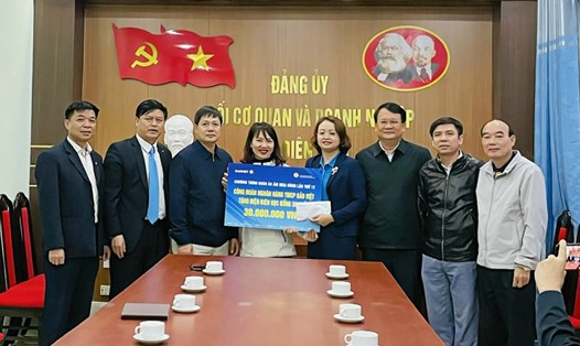 Đại diện lãnh đạo Tập đoàn Bảo Việt trao tặng 30 suất học bổng cho đại điện Công đoàn Viên chức tỉnh Điện Biên để chuyển đến con công nhân lao động. Ảnh: Bảo Ngọc