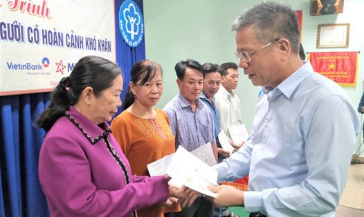 Ông Trần Đình Liệu - Phó Tổng giám đốc BHXH Việt Nam - trao sổ BHXH tự nguyện cho người dân. Ảnh: Nam Dương