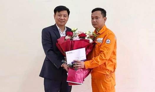 Chủ tịch Công đoàn Công ty Điện lực Lào Cai tặng hoa và khen thưởng cho công nhân Nguyễn Đức Thành. Ảnh: Điện lực Lào Cai