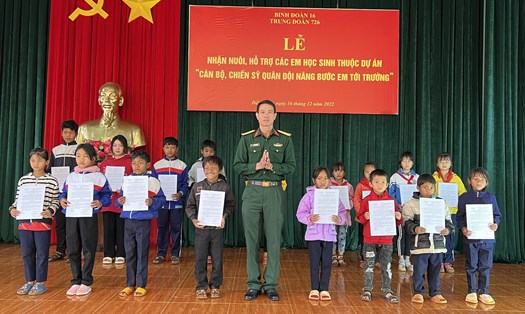Thượng tá Nguyễn Văn Huệ, Phó Bí thư Đảng ủy, Trung đoàn trưởng Trung đoàn 726 trao quyết định nhận nuôi và hỗ trợ cho các em học sinh. Ảnh: Hồng Thắm