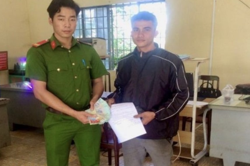 Trung sĩ Bùi Hoàng Phi trao trả lại tài sản cho anh Cường. Ảnh: Công an Đồng Nai