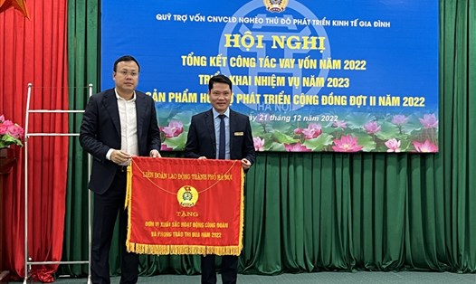 Chủ tịch Liên đoàn Lao động Thành phố Hà Nội Phạm Quang Thanh (bên trái) trao Cờ thi đua cho Quỹ. Ảnh: Linh Nguyên