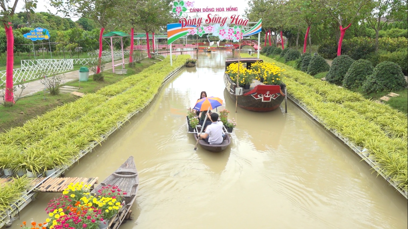 Khách tham quan thích thú trải nghiệm bơi xuồng hoa tại điểm du lịch Cánh đồng hoa hồng. Ảnh: Thanh Nghĩa