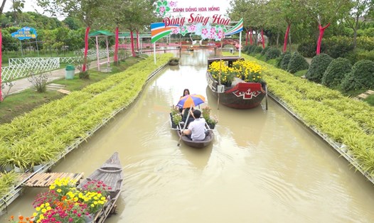 Khách tham quan thích thú trải nghiệm bơi xuồng hoa tại điểm du lịch Cánh đồng hoa hồng. Ảnh: Thanh Nghĩa