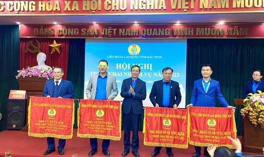 Ông Tống Văn Băng – Uỷ viên Đoàn Chủ tịch, Trưởng ban Tổ chức Tổng Liên đoàn Lao động Việt Nam - trao Cờ thi đua cho các tập thể có thành tích xuất sắc năm 2022. Ảnh: N.Hoàng