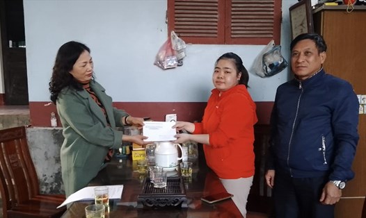 Phó Chủ tịch LĐLĐ huyện Quốc Oai Nguyễn Thị Trang trao trợ cấp đột xuất cho chị Hà Thị Mai Hưng (áo đỏ). Ảnh: Quang Bảy
