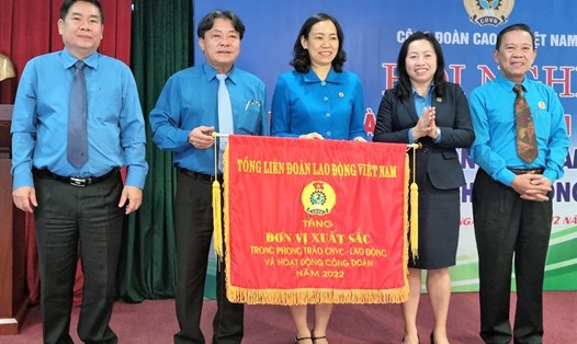 Phó Chủ tịch Tổng LĐLĐVN Thái Thu Xương (thứ hai, từ phải qua) tặng Cờ của Tổng LĐLĐVN cho Công đoàn Caosu Việt Nam. Ảnh: Nam Dương