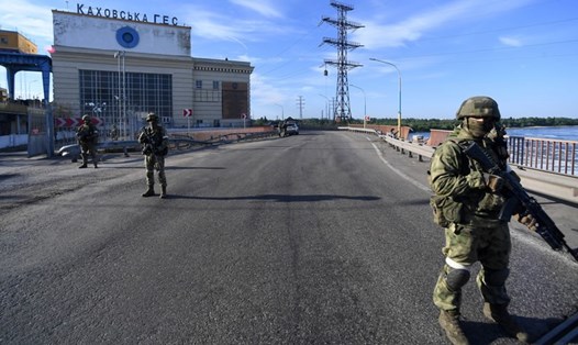 Quân nhân Nga đứng trước nhà máy thủy điện Kakhovka ở tỉnh Kherson, Ukraina. Ảnh: Sputnik/BQP Nga