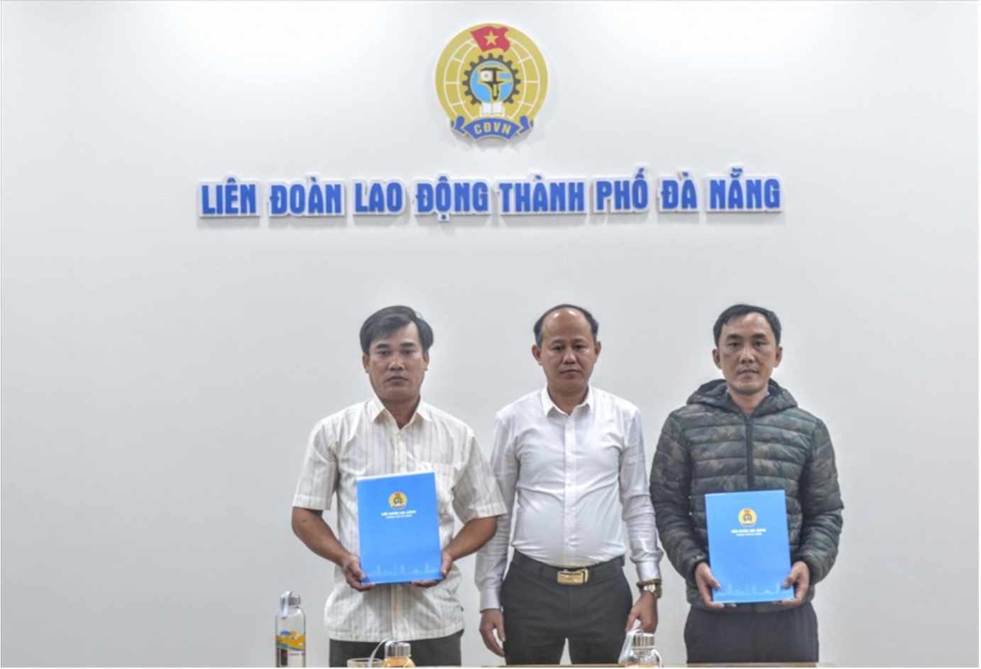 Ông Lê Văn Đại (giữa) - Phó chủ tịch LĐLĐ thành phố Đà Nẵng - bàn giao kinh phí xây dựng nhà Mái ấm Công đoàn cho 2 đoàn viên. Ảnh: Trà Vân